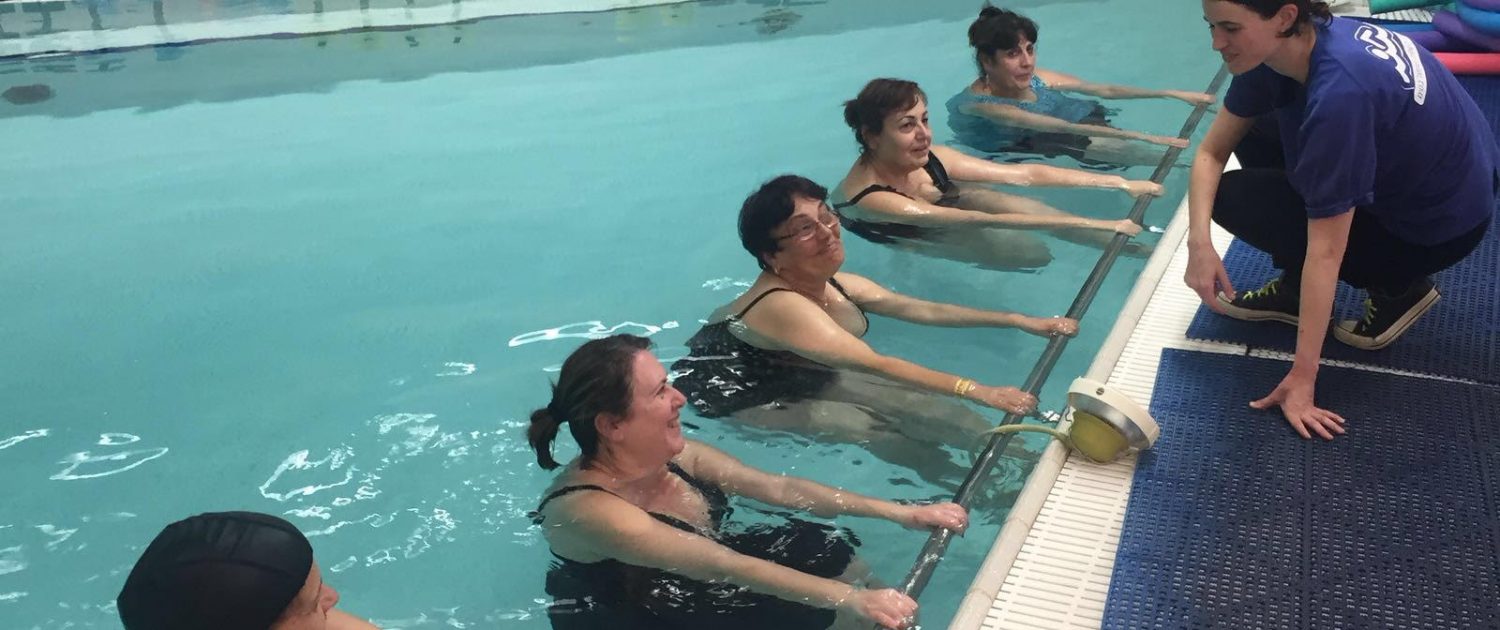 מדריכה בבריכה יחד עם המתעמלות שלה בחוג התעמלות במים מדריכה בבריכה יחד עם המתעמלות שלה בחוג התעמלות במים